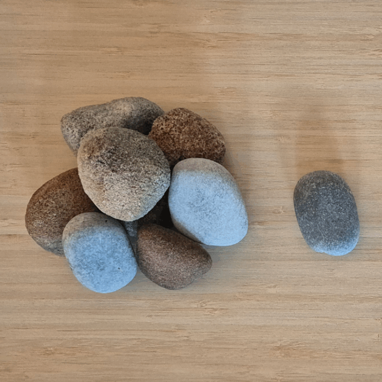 A bird's-eye view of a variety of stones with different textures on a wooden table.