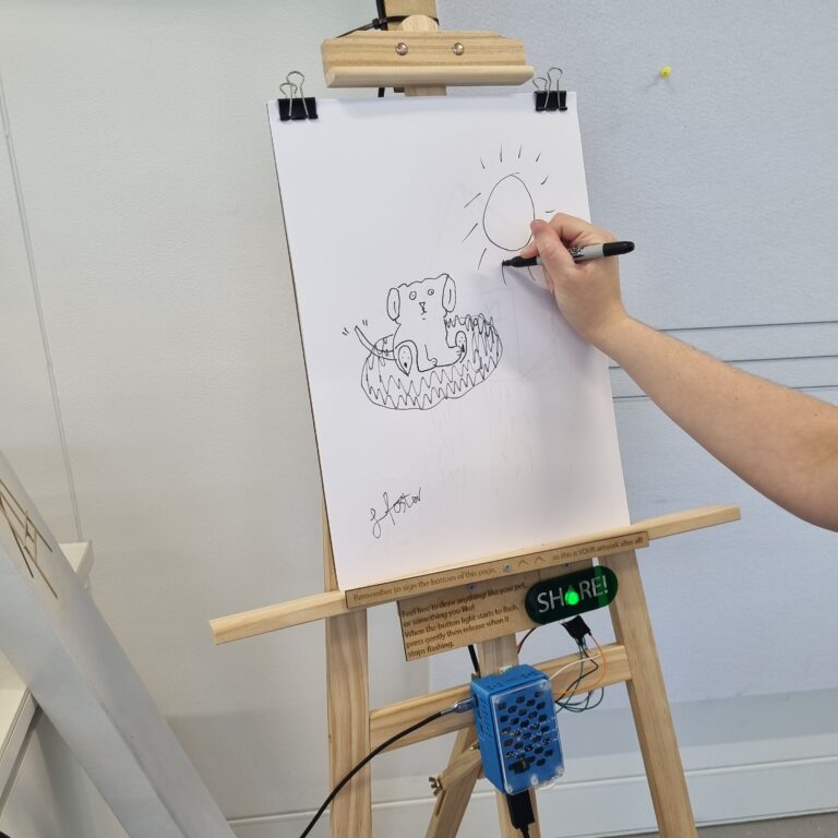 Photograph of the canvas being used to draw, while the Raspberry Pi and button are located underneath.