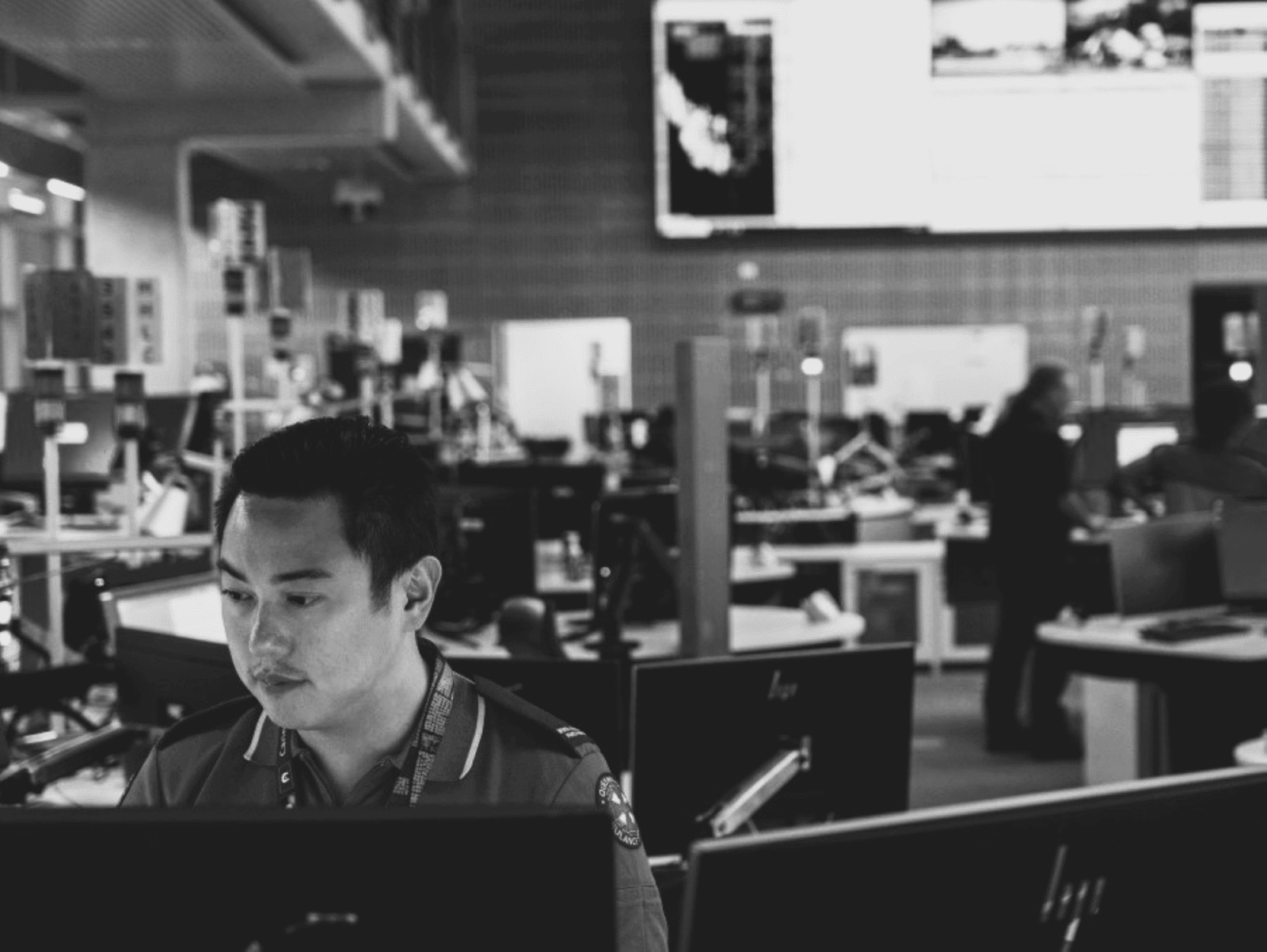 Emergency call dispatcher in overcrowded workspace.