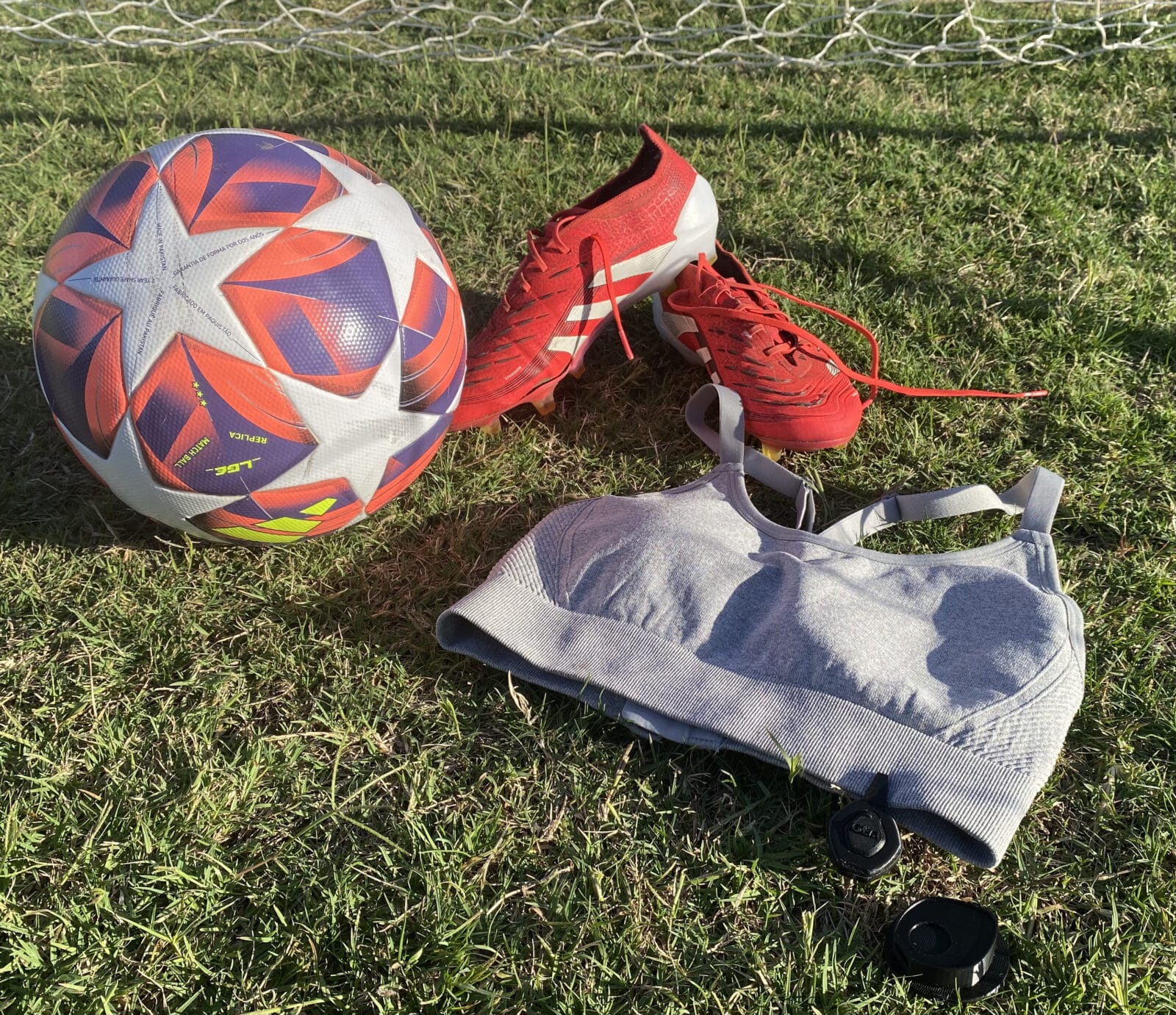 GEM product attach to sports bra, surrounding by football boots and ball. 