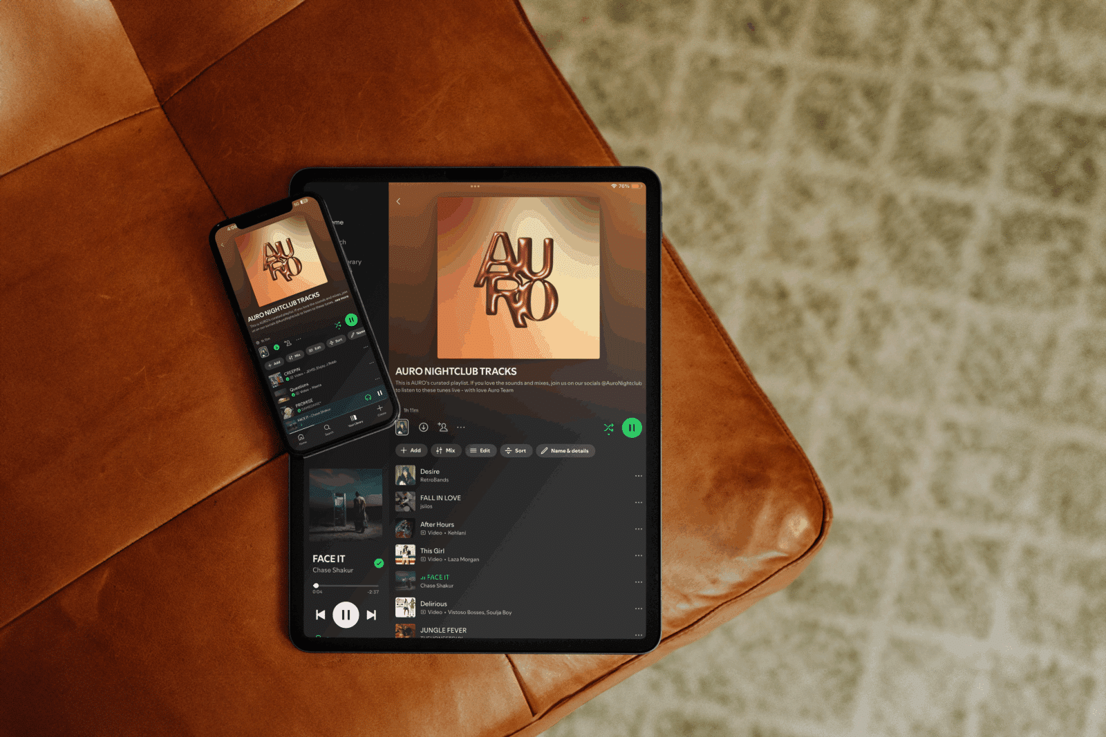 Image captures AUROs Spotify on an iPad and mobile phone on an orange leather couch captured from above