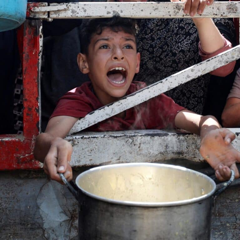 Reuters A Palestinian child is caught mid shout, eyes full of anguish, as he waits to receive food from a charity kitchen, amid a hunger crisis in Gaza