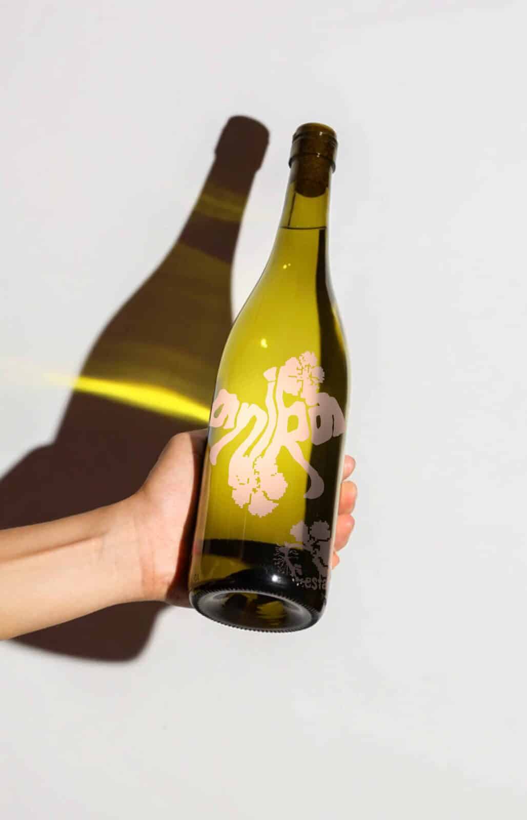 Anika Estate wine bottles featuring minimalist pink illustrations of grapevines and leaves, photographed on a light background. The design highlights the organic, contemporary branding of Anika Estate, reflecting a balance between contemporary design and natural inspiration.